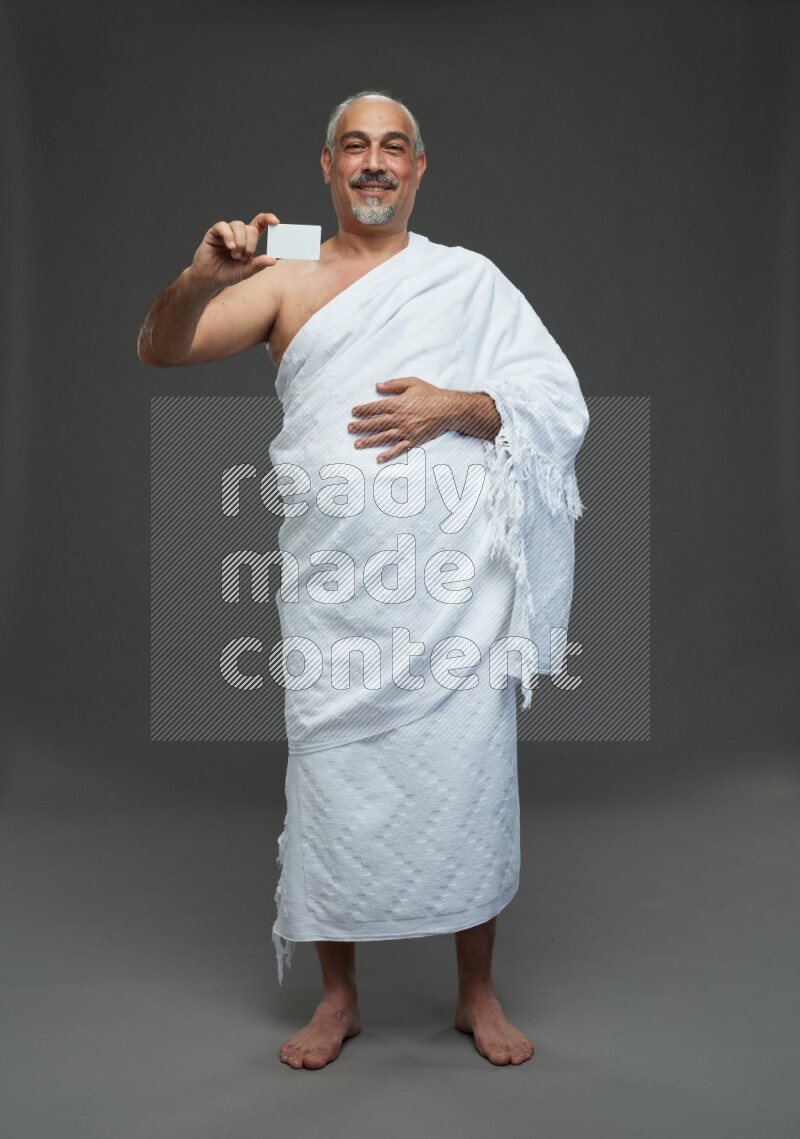 A man wearing Ehram Standing holding ATM card on gray background