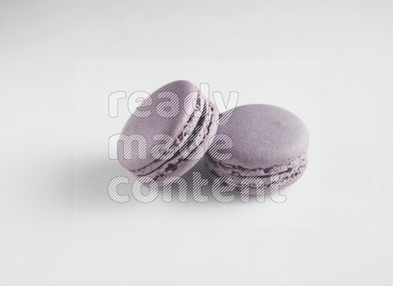 45º Shot of two Purple Blueberry macarons on white background