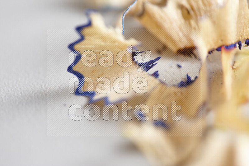 صورة مقربة تظهر كومة صغيرة من نشارة الأقلام ذات حواف ملونة متنوعة علي خلفية رمادية