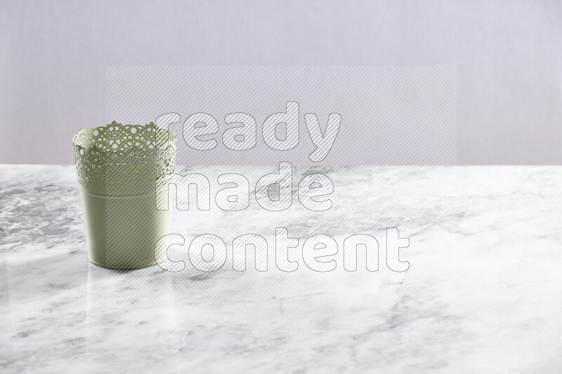 An empty green plant pot on grey marble background