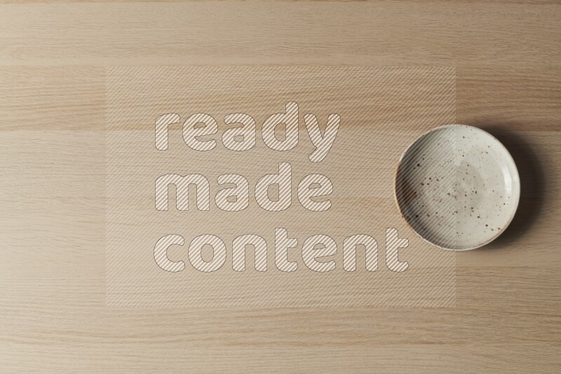 A multicolored pottery plate on light wooden background