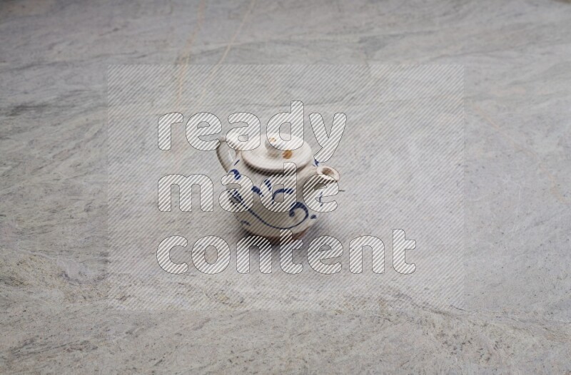 A pottery teapot on grey marble background