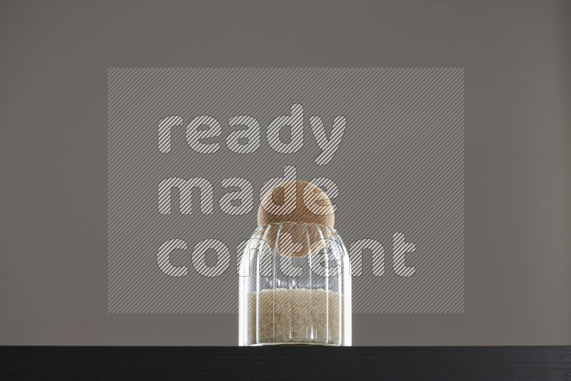 White rice in a glass jar on black background