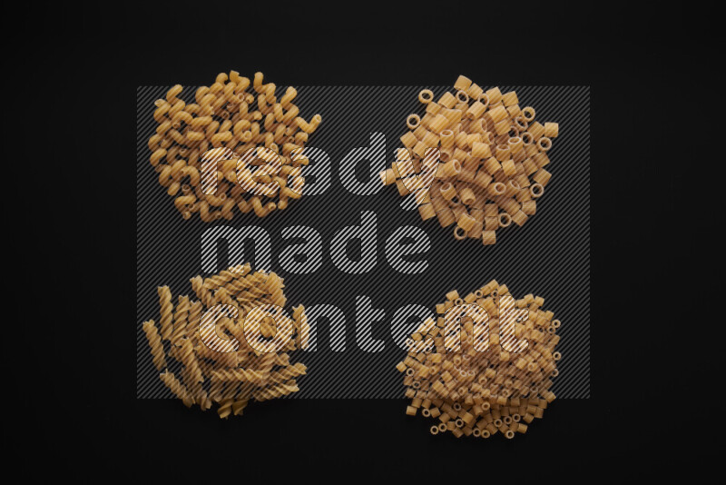 Different pasta types in bunches on black background