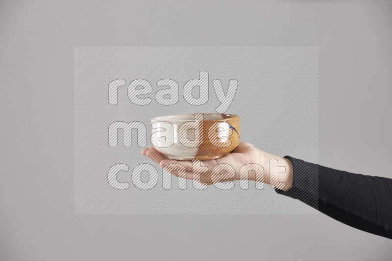 A woman in black abaya holding different pottery essentials in different positions