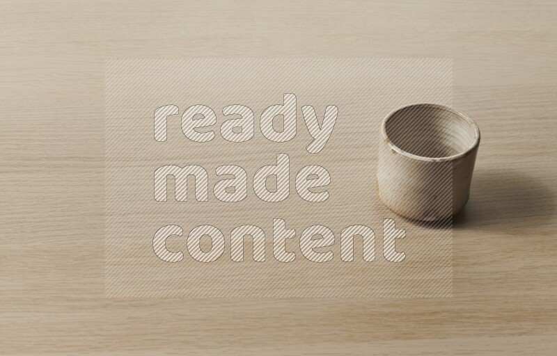 A pottery cup on light wooden background