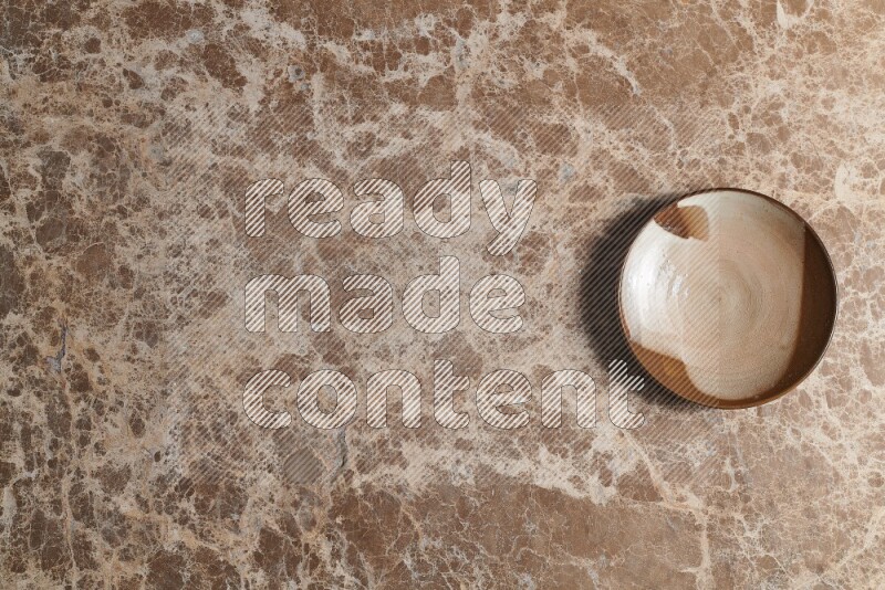 A decorative pottery plate on beige marble background