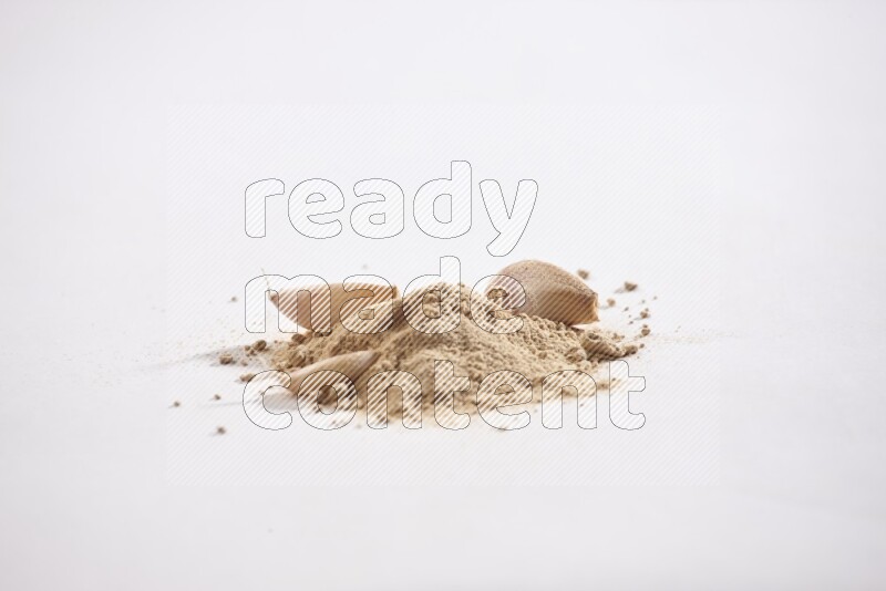 A small pile of garlic powder with some of cloves and a whole garlic bulb on a white flooring