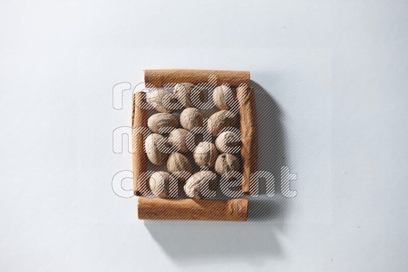 A single square of cinnamon sticks full of nutmeg on white flooring