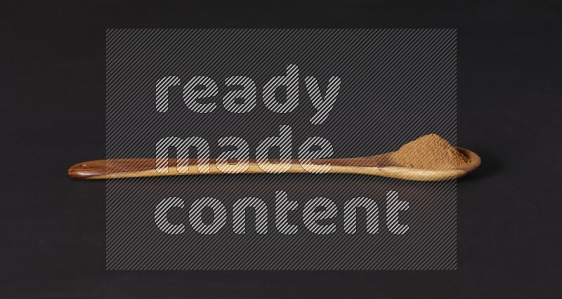 Cinnamon powder in a wooden ladle spoon on black background in different angles