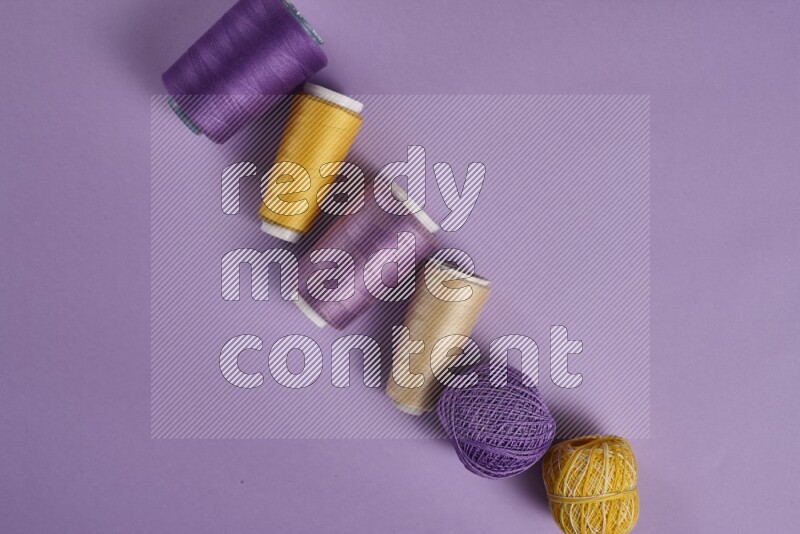 A yellow and purple collection of sewing and tailoring tools arranged on a purple background