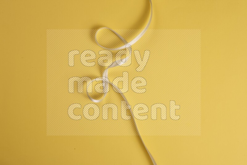 A green collection of sewing and tailoring tools arranged on a yellow background