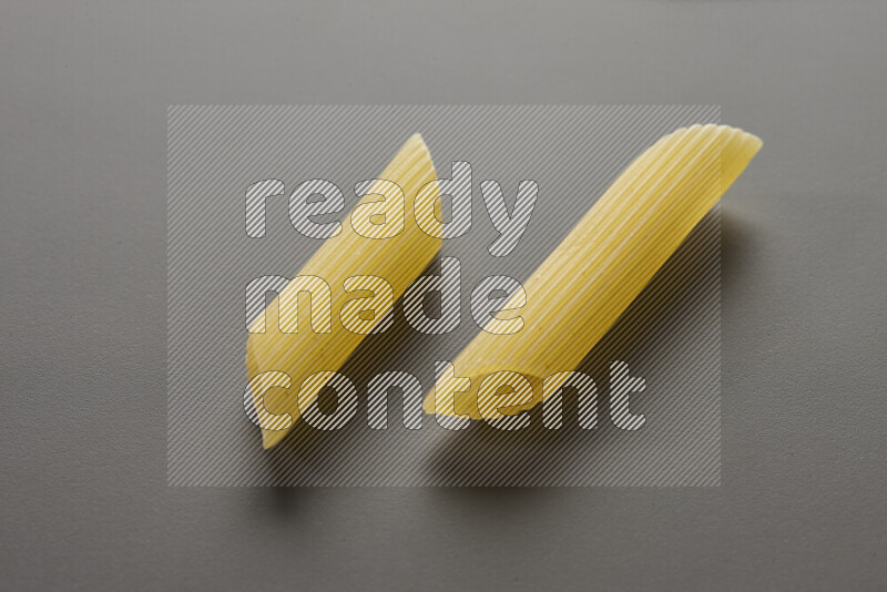 Penne pasta on grey background