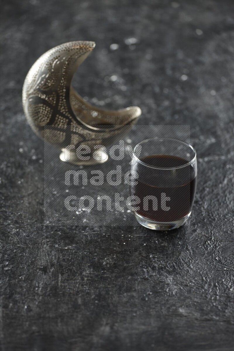 فانوس فضي مع مشروبات مختلفة وتمر ومكسرات وسبحة صلاة وقرآن على خلفية سوداء