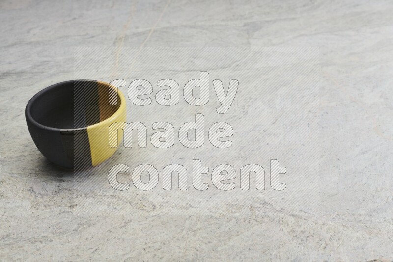 A multicolored pottery bowl on grey marble background