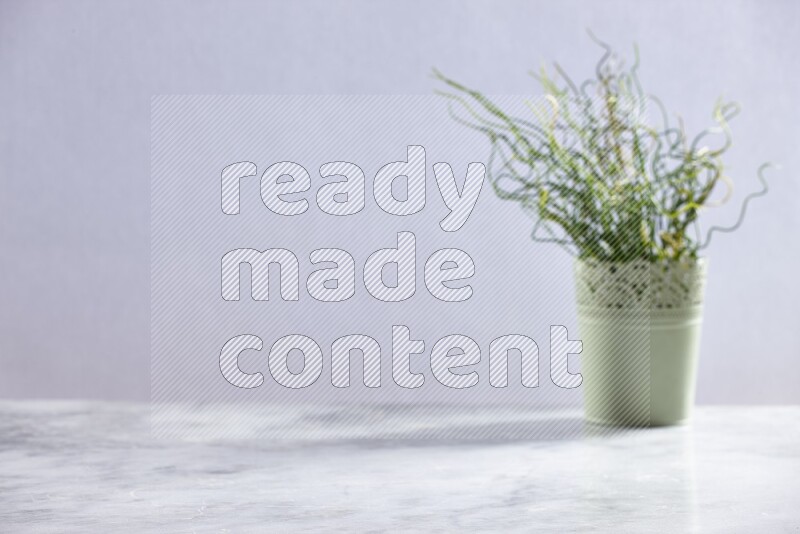 Artificial plant in green decorative pot on grey marble background