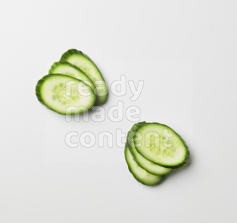 Multiple cucumber slices on white background