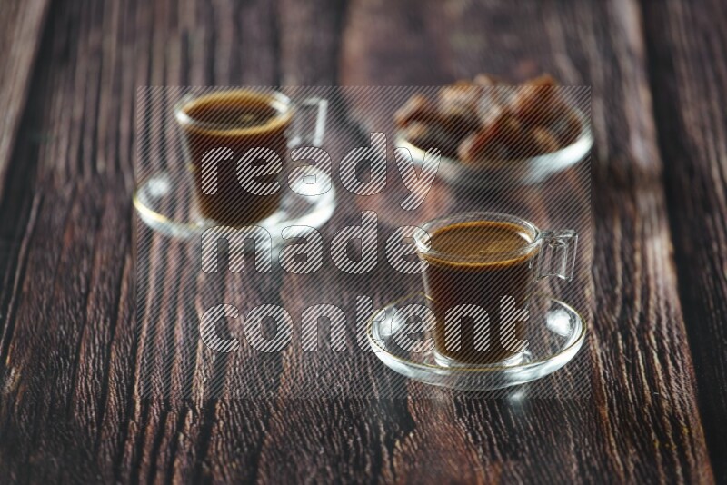 A coffee glass cup with dates and tea on wooden background