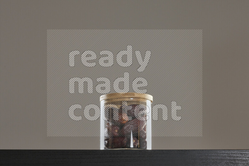 Dates in a glass jar on black background