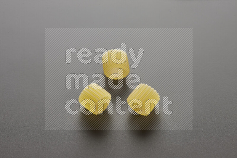 Big rings pasta on grey background