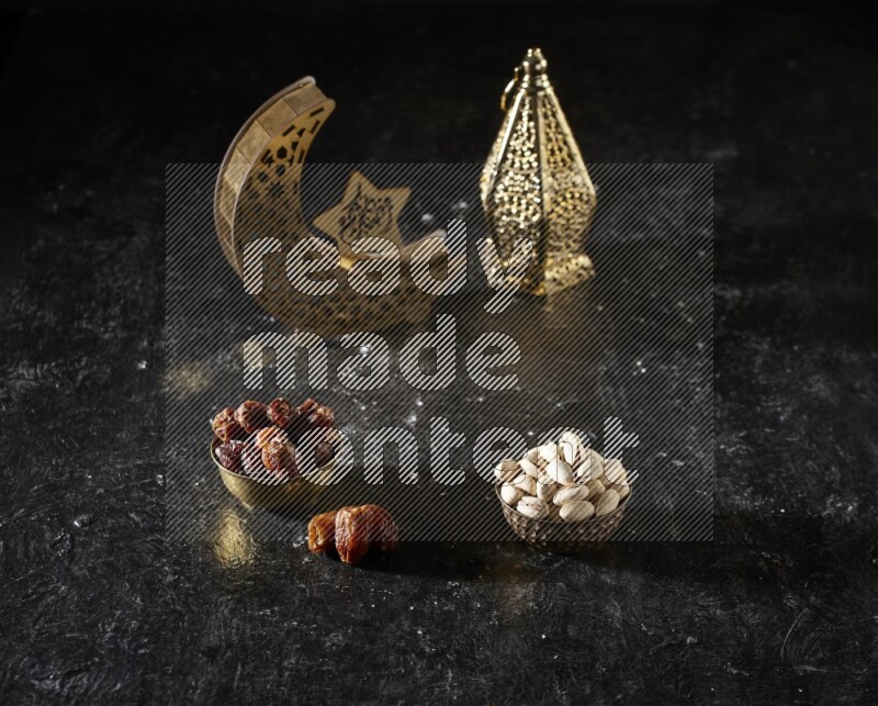 تمر في وعاء معدني مع الفستق بجانب فوانيس ذهبية علي خلفية سوداء