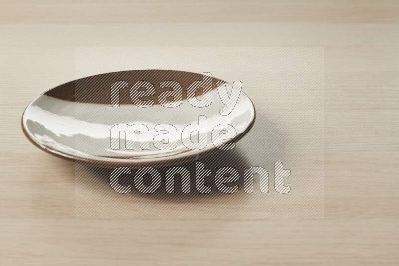 صحن فخاري متعدد الألوان على خلفية خشبية فاتحة