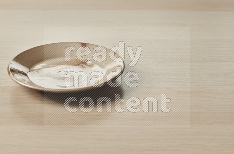 صحن فخاري متعدد الألوان على خلفية خشبية فاتحة