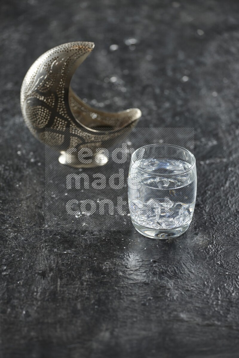 فانوس فضي مع مشروبات مختلفة وتمر ومكسرات وسبحة صلاة وقرآن على خلفية سوداء