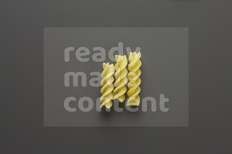 Fusilli pasta on grey background