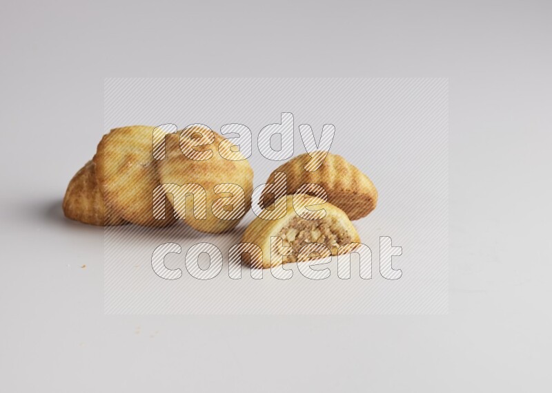 Five Pieces of Maamoul filled with walnut paste  one of them is cut with direct on white background