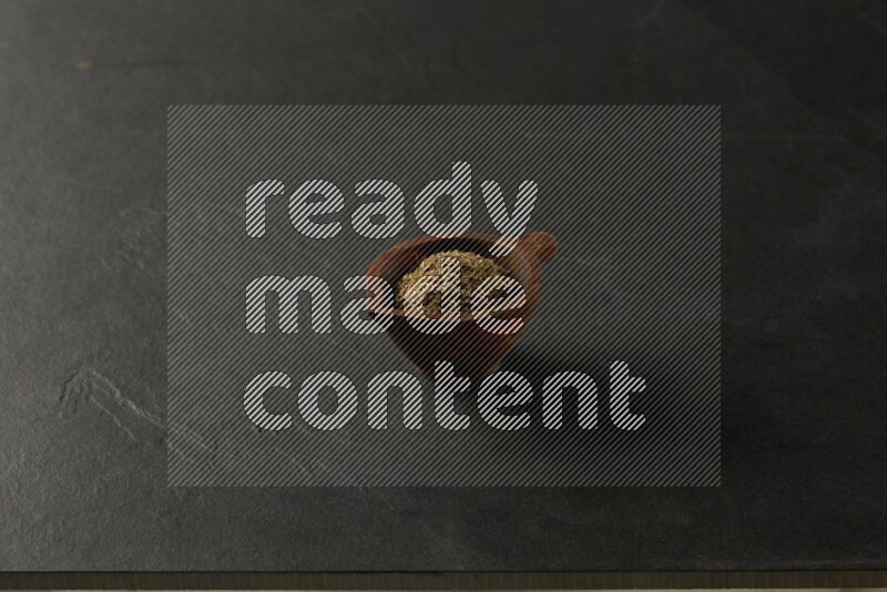 wooden round sauce bowl filled with herbs on grey textured countertop