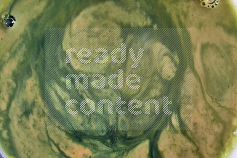 A close-up of abstract swirling patterns in orange and green