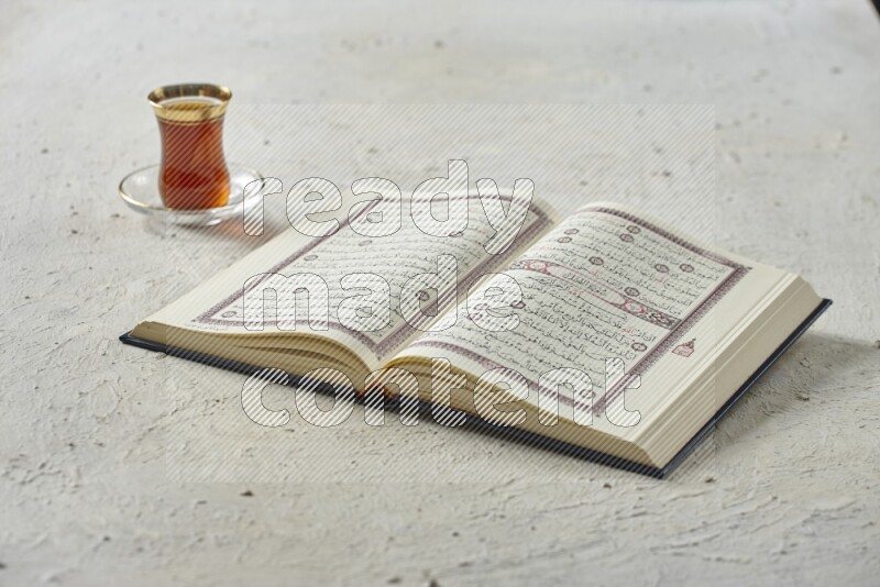Quran with dates, prayer beads and different drinks all placed on textured white background