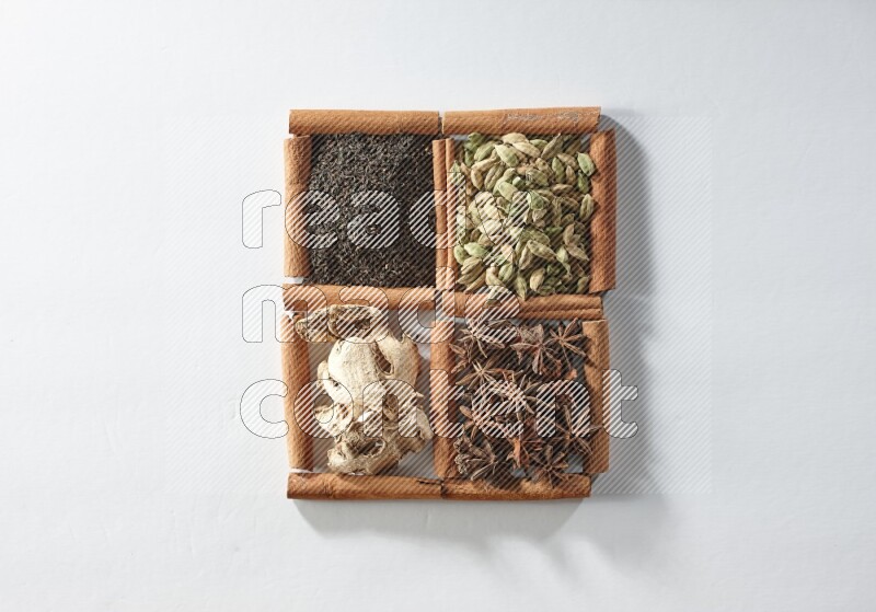 4 squares of cinnamon sticks full of tea, cardamom, star anise and ginger on white flooring