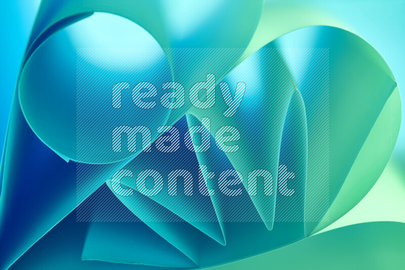 عرض فني لطيات الورق تخلق مزيج من الأشكال الهندسية، مضاءة بإضاءة ناعمة بدرجات اللون الأخضر والأزرق