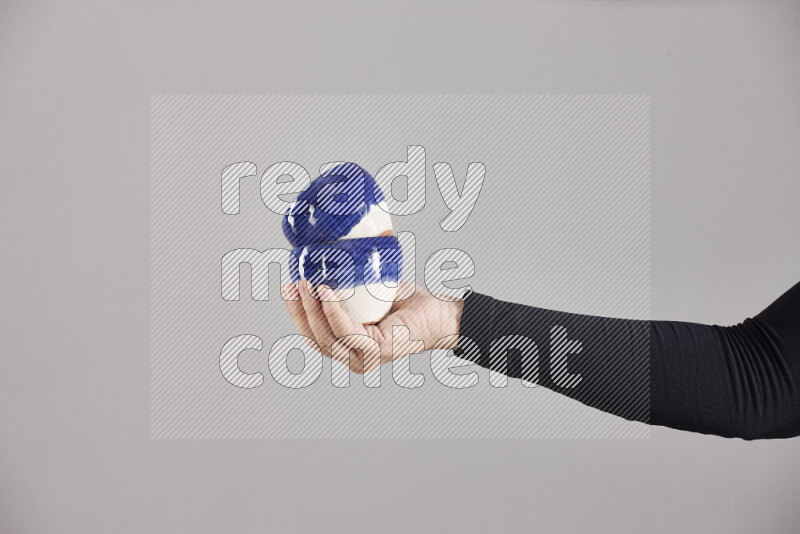 A woman in black abaya holding different pottery essentials in different positions