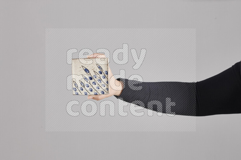 A woman in black abaya holding different pottery essentials in different positions