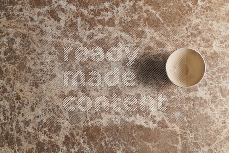 A white pottery bowl on beige marble background