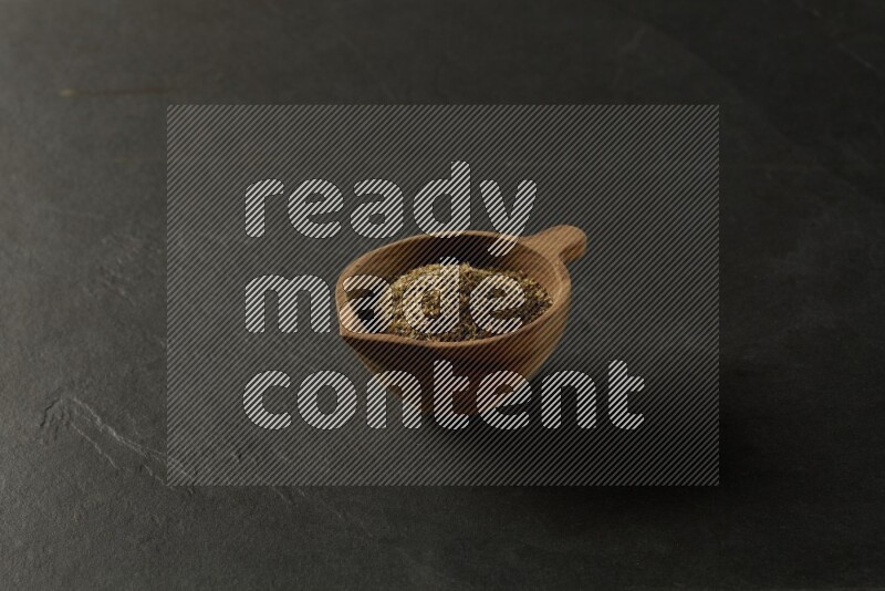 wooden round sauce bowl filled with herbs on grey textured countertop