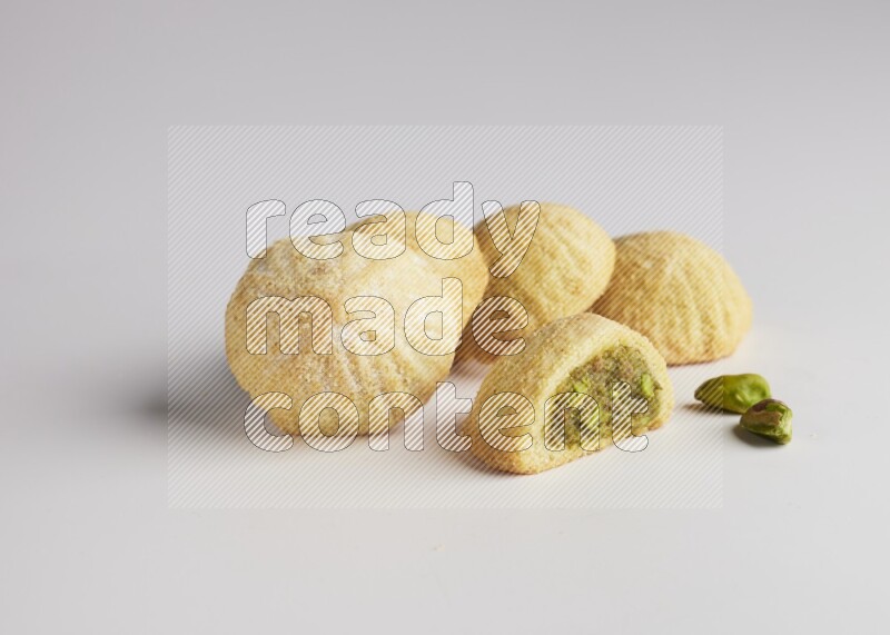 Five Pieces of Maamoul filled with pistachio  paste one of them is cut direct on white background