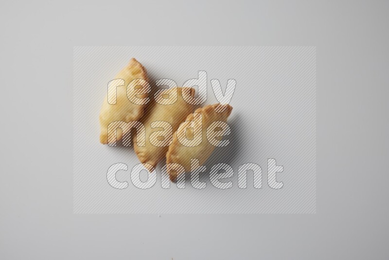 Three fried sambosa from a top angle on a white background