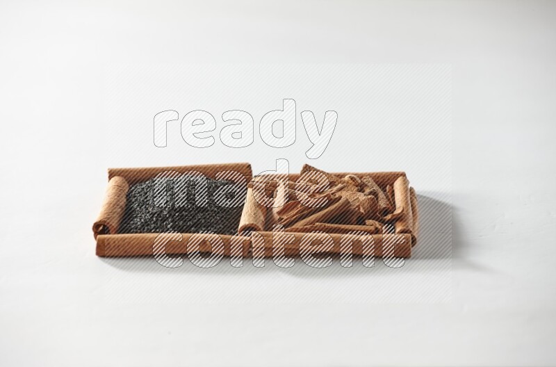 2 squares of cinnamon sticks full of black seeds and cinnamon on white flooring