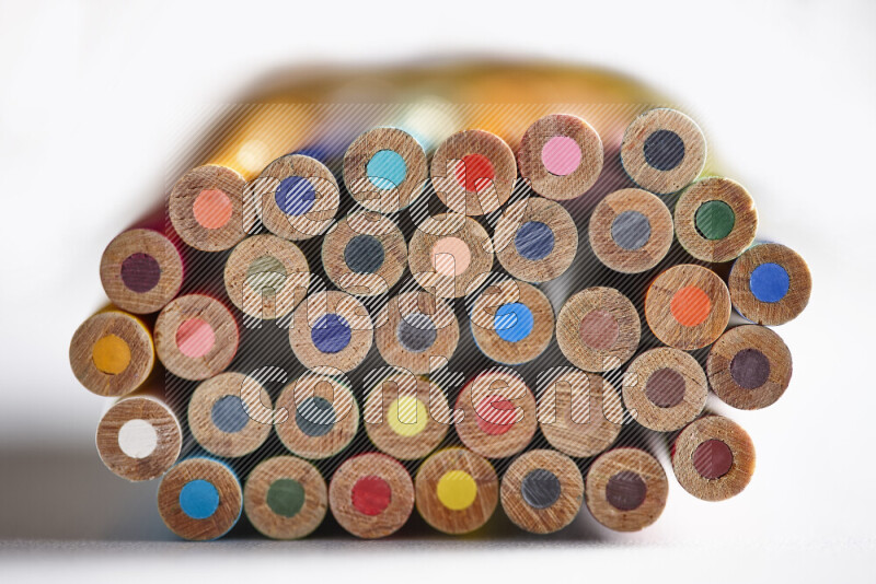 صورة مقربة لأطراف أقلام خشبية ملونة مرتبة في مجموعة علي خلفية بيضاء