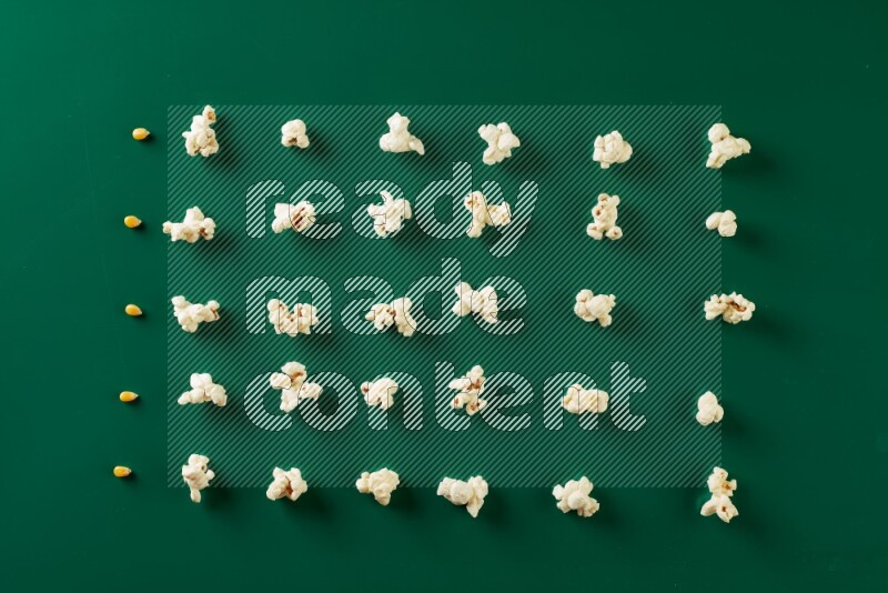 Popcorn flakes and seeds on a green background in a top view shot