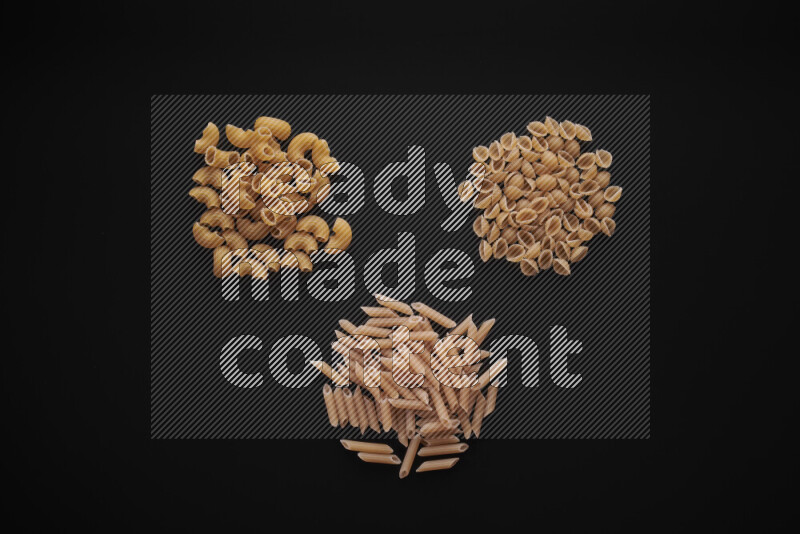 Different pasta types in bunches on black background