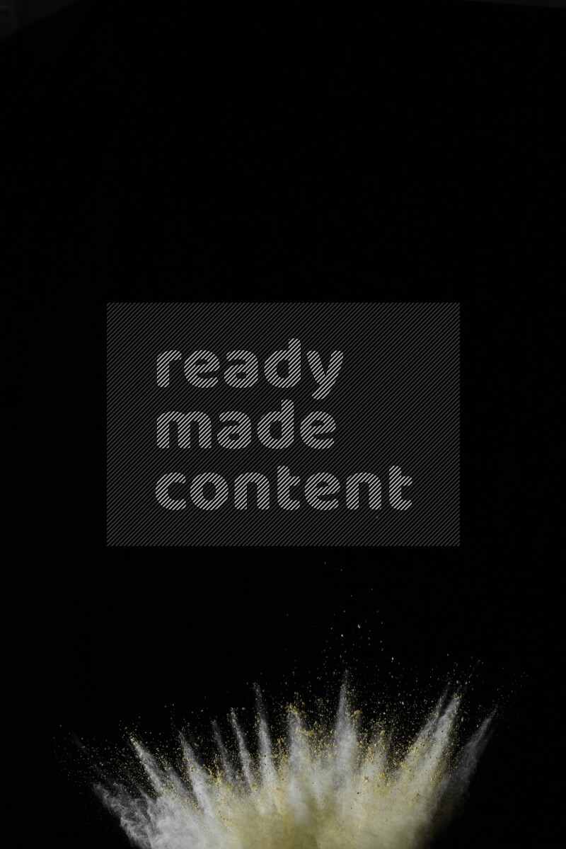 A side view of yellow powder explosion on black background
