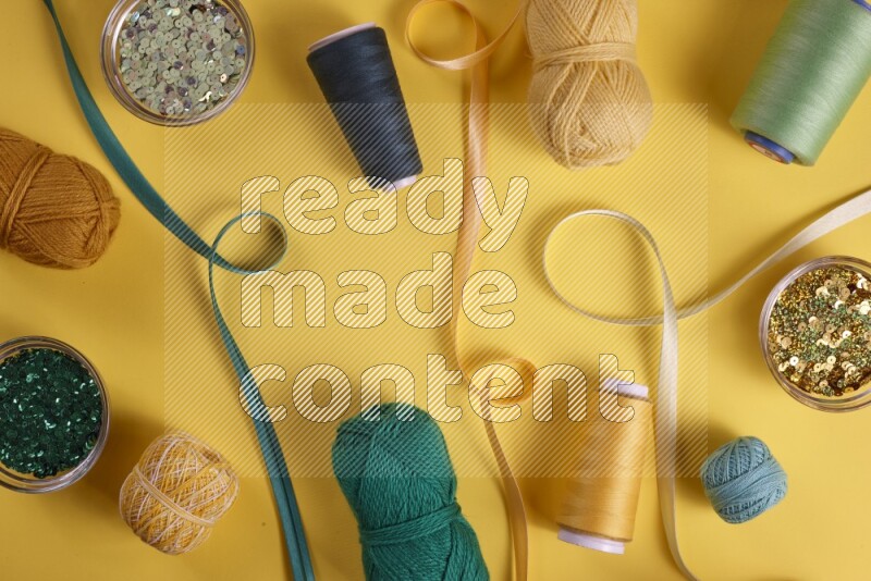 A green collection of sewing and tailoring tools arranged on a yellow background