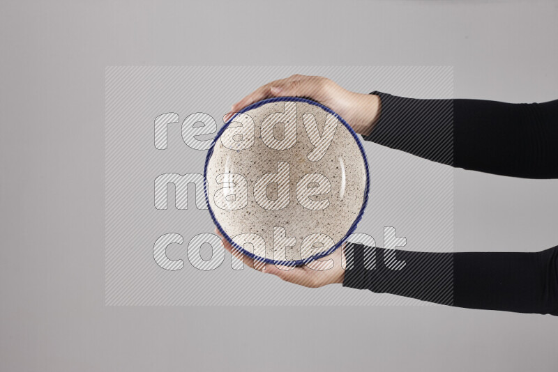 A woman in black abaya holding different pottery essentials in different positions