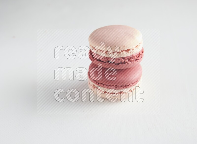 45º Shot of two Pink Litchi Raspberry macarons on white background