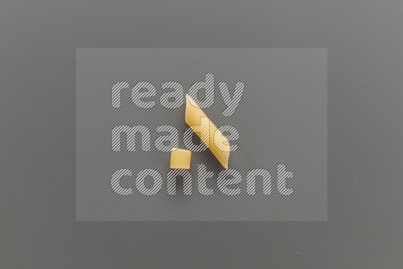 Big rings pasta with other types of pasta on grey background